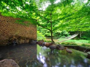 川の湯・岩露天風呂(昼)　※豊沢川と木々に囲まれて、森林浴をしながら温泉をご満喫いただけます。
