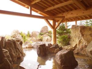 ◆１F露天岩風呂・昼／巨岩を組み合わせた野趣満点の湖畔露天風呂（一例）