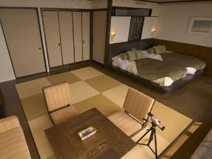 和洋室（バルコニー付）／琉球畳のリビングスペースとゆったりサイズのベッドでのんびりお過ごし頂けます（一例）