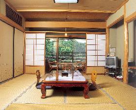8畳和室　窓の向こうは緑豊かな田舎景色。　洗面所、ウォシュレットトイレ付き　寝具は羽毛布団　2名様から4名様までご利用いただけます。