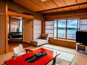 専用露天風呂一例。日本庭園と柴山潟をご覧いただけます。いつでもお好きな時に温泉をお楽しみください。