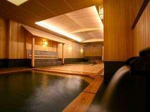 香り高い檜と軟石を使用した大浴場。大小の湯船を備えております。