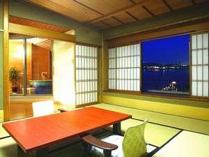 【温泉露天風呂付和室】左側が露天風呂。右側が柴山潟です。点のような明かりは弁天様の『浮御堂』です。