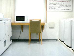 全自動洗濯機４台・ガス式衣類乾燥機２台のランドリーコーナー。電子レンジも設置。
