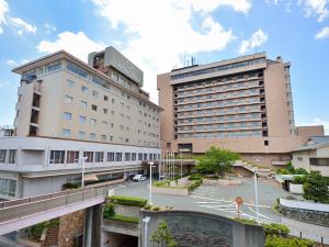 ◆ホテル外観（昼）：正面左側の建物が入口・フロント、隣の新館へはエスカレーターでつながっております。