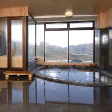 ＨＯＴＥＬ万葉岬の大浴場。岩風呂と露天のひのき風呂の展望風呂がございます。果てしなく広がる紺碧の空と海をお楽しみいただきながら、満ち足りた至福の時間をお過ごしくださいませ。