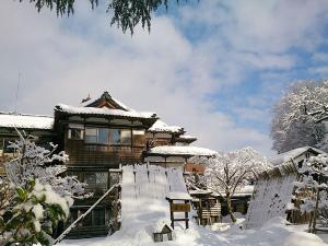 【冬の外観】すっぽりと雪に覆われた嵐渓荘。夜は温かな明かりが灯ります。