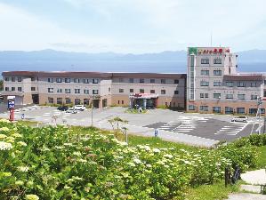 ホテル外観。背景に見える山並みは北海道です。
