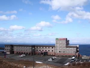 冬のホテル外観。背景の壮観な雪の山並みは北海道です。