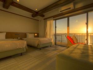 てぃーだ館スーペリアツインのお部屋に流れ込む夕焼け