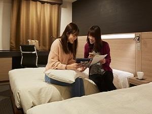 【モデレートツイン】女子旅にオススメの20平米 ベッドに腰掛けて観光プランを考えてみてはいかがでしょうか。