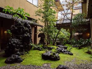*【1F中庭】ロビーに面した中庭は大切に育ててきた苔の緑と木々や銘石との調和をお楽しみいただけます。