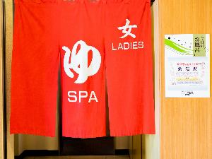 【女湯入口】フロント左側の赤い暖簾が目印でございます。