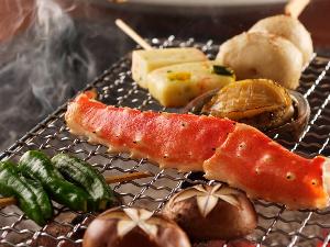 囲炉裏で焼く「魚介の網焼き」です（プラン・時節により変更がございます）