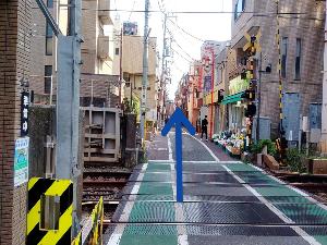 踏切を渡り矢印の方向へ直進くださいませ。