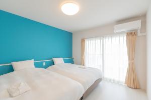 【ファミリースイート】こちらはメインベッドルーム。140センチ幅の2台のベッドで広々とお寛ぎ頂けます。