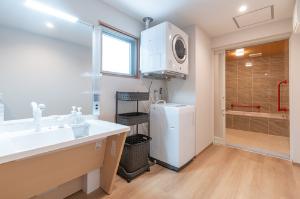 【デラックススイート】広々とした洗面所はお出かけ前の身支度にちょっとした余裕をくれます♪また、嬉しい洗濯機・乾燥機付き！洗濯用洗剤は1回分50円でフロントにて販売中。