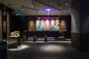 【7F ロビー】ススキノのネオンも想起させるカラフルな色つかいが空間に色どりを与えるアートを背景にしたフロントカウンター