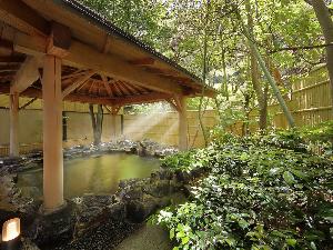 【男性用大浴場】石造り露天風呂（昼景）湯けむりと里山の心地よい風に包まれる露天風呂です。