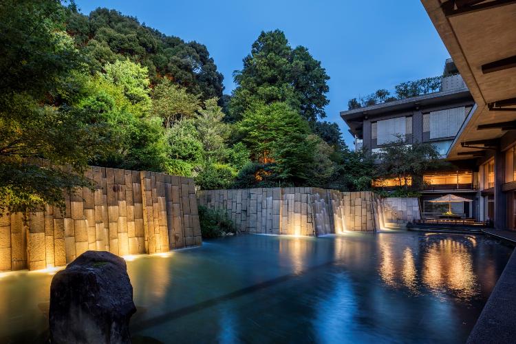 ロビーラウンジ「山草花」：夜には滝の流れる庭園がライトアップいたします。