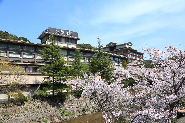 大谷山荘の外観：大谷山荘前の音信川沿い。毎年3月下旬～4月上旬頃、桜の季節を迎えます。