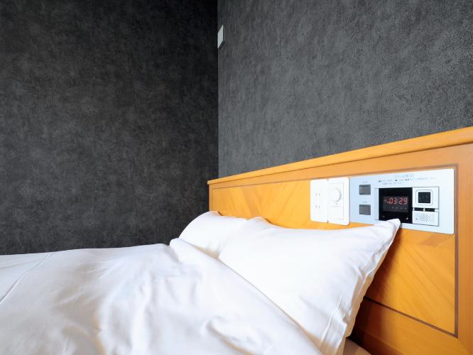 【洋室ダブル】枕元にアラームやスイッチ、コンセント設備がございます。