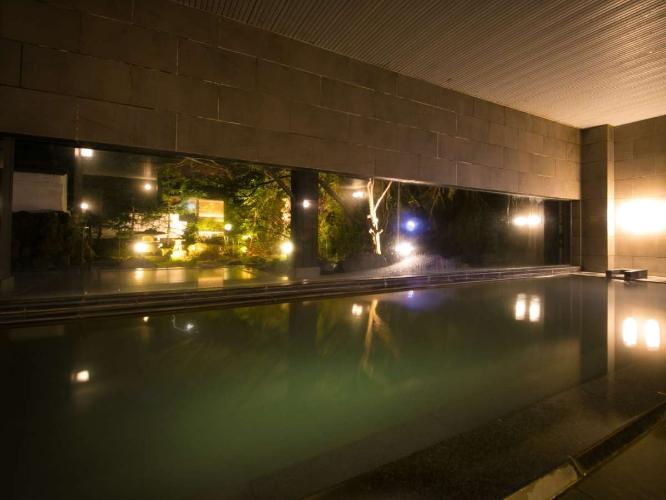 【大浴場】夜になるとライトアップされた日本庭園と白濁したお湯が共鳴し、幻想的な世界を作り出します。