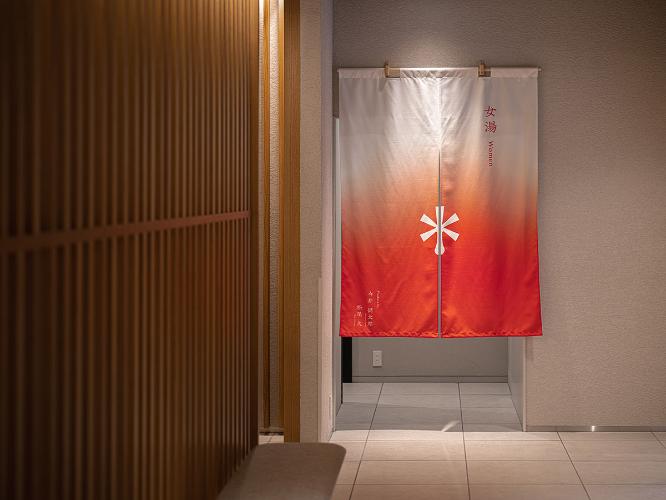 女湯入口｜ホテルロゴをあしらったのれんがお出迎えいたします。