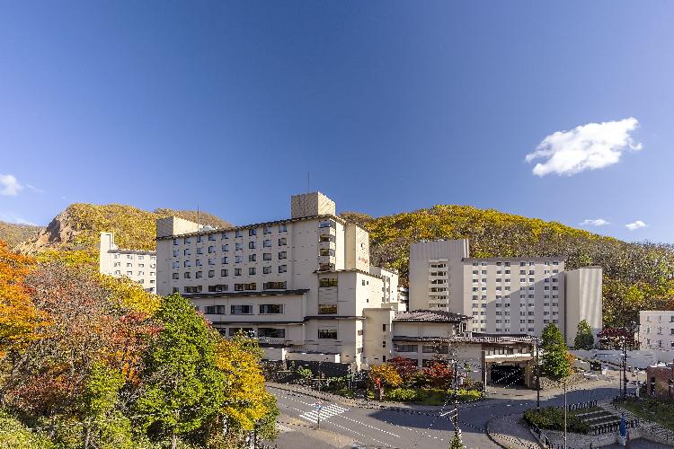 第一滝本館　外観（秋）　紅葉の見ごろは10月中旬です。山々に囲まれた登別温泉が色づく様子をお楽しみください。