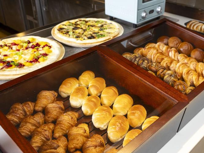 朝食ビュッフェ／パンコーナーには数種類のパンやピザが並びます（イメージ）