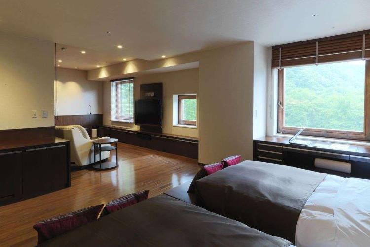 【岩盤浴付DXツイン】お部屋はゆったり広々の63平米。窓の外は定山渓の大自然が広がります（客室一例）