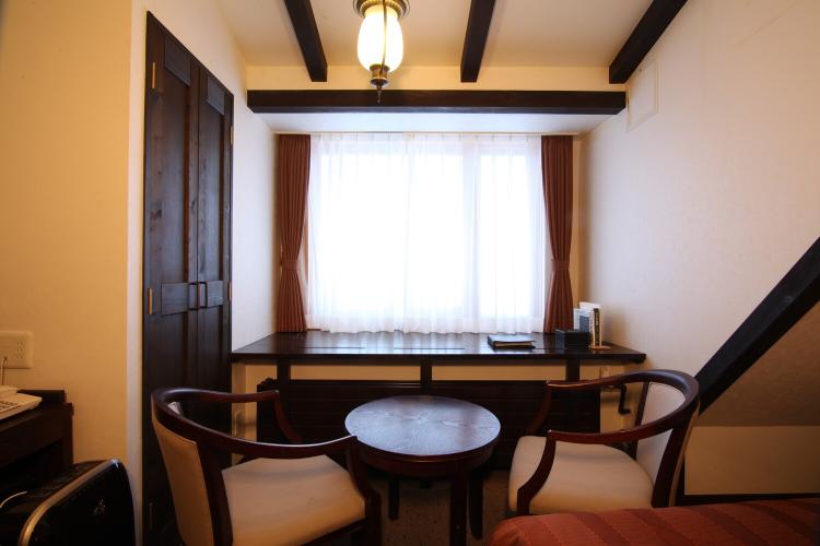 【コンフォートツイン/29平米】椅子に腰かけて窓からの自然を愉しむ優雅なお時間をご提供。