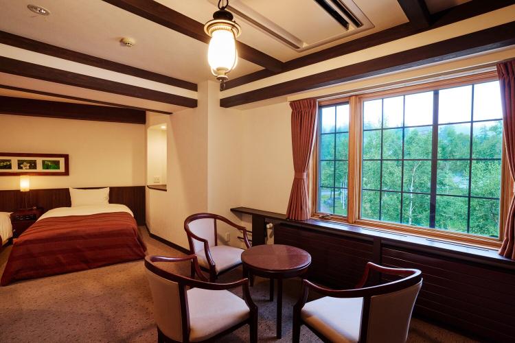 【デラックストリプル/42平米】大自然が顔を覗かせる窓側、イスで休みながら自然の心地よさをご堪能。