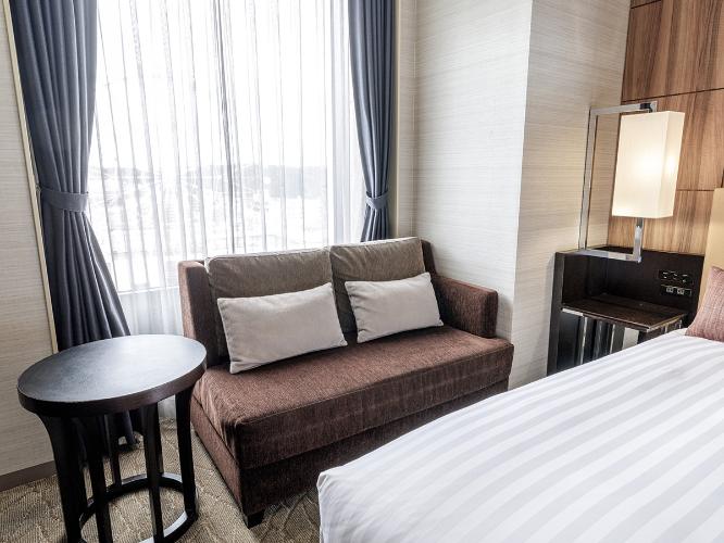 【観覧車側コーナーダブルルーム 22.2平米/ベッド幅160cm】シティビューを望むコーナーダブルはクイーンサイズのベッドと旅の疲れを癒すくつろぎのビューバス、独立した洗面・バスルームをご用意