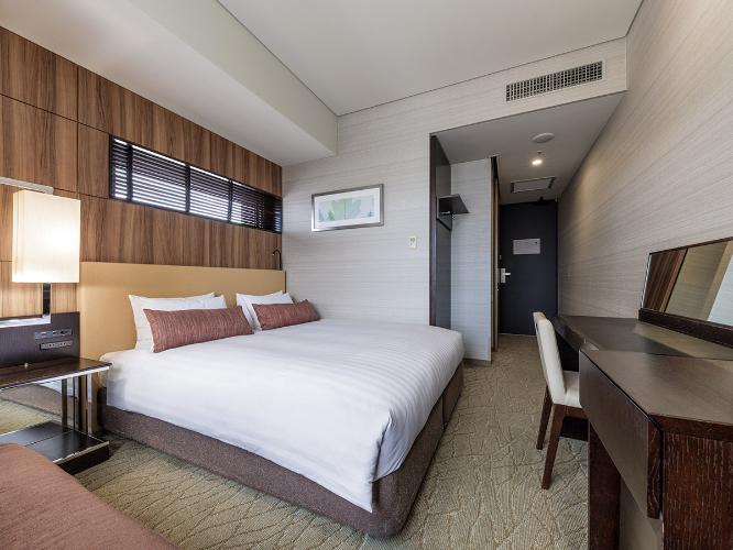 【観覧車側コーナーダブルルーム 22.2平米/ベッド幅160cm】シティビューを望むコーナーダブルはクイーンサイズのベッドと旅の疲れを癒すくつろぎのビューバス、独立した洗面・バスルームをご用意