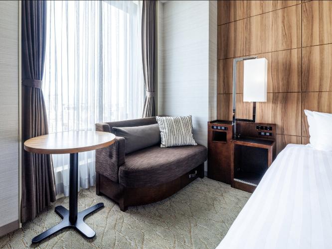 【桜島側ダブルルーム 17.7平米/ベッド幅150cm】雄大な桜島を望むことができるダブルルームは、くつろぎのソファスペースとナチュラルでやさしいデザインにこだわりました。