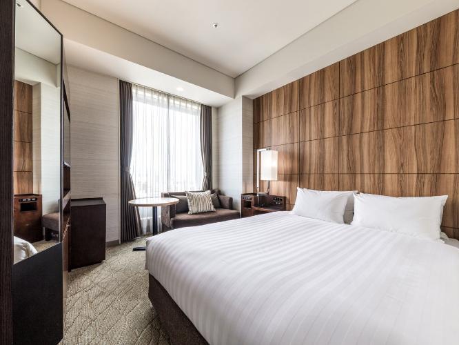 【桜島側ダブルルーム 17.7平米/ベッド幅150cm】雄大な桜島を望むことができるダブルルームは、くつろぎのソファスペースとナチュラルでやさしいデザインにこだわりました。