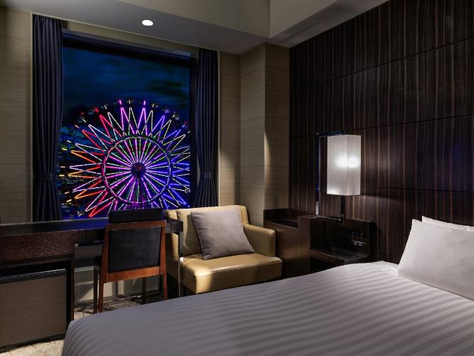 【観覧車側セミダブル 17.7平米/ベッド幅140cm】どのシーンにも機能的なセミダブルルームからは、シティビューが望めます。ゆったりと過ごせるベッドで、快適な朝をお迎えください。