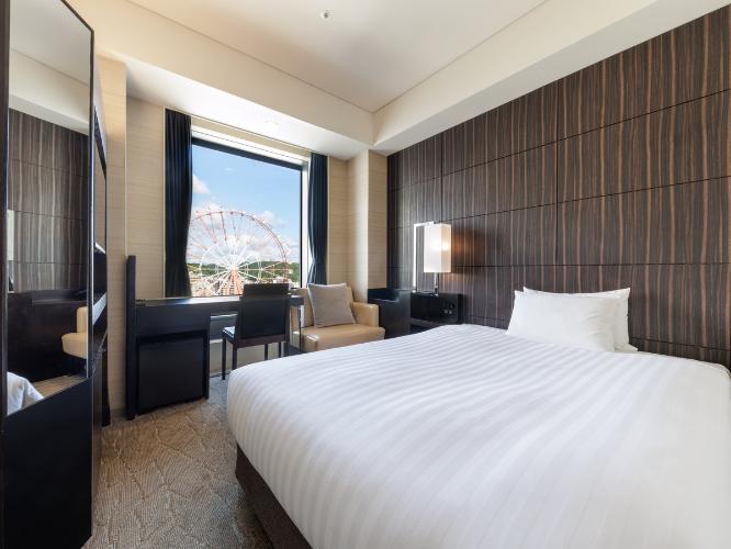 【観覧車側セミダブル 17.7平米/ベッド幅140cm】どのシーンにも機能的なセミダブルルームからは、シティビューが望めます。ゆったりと過ごせるベッドで、快適な朝をお迎えください。