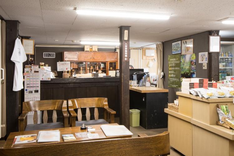 【館内/共有スペース】温かみのある帳場（フロント）。皆様を真心込めた笑顔でお迎えいたします。